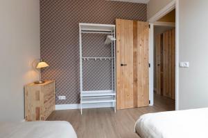 a bedroom with a closet and a bed and a door at Hoeve Koning Willem III in Frederiksoord