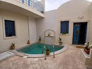 a swimming pool in a large room with a pool at Dar El Hara in Houmt Souk