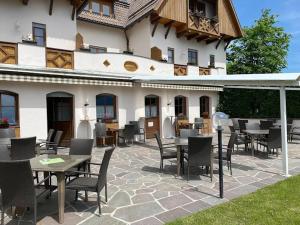 a patio with tables and chairs in front of a building at Hotel Lengsteinerhof in Longostagno