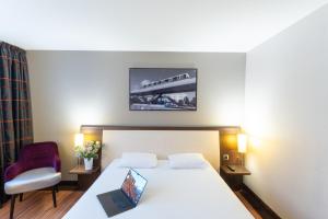 a hotel room with a bed with a laptop on it at Hotel Mercure Rennes Cesson in Cesson-Sévigné +58 photos