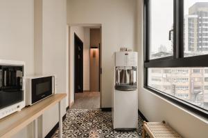 a room with a refrigerator and a tv and windows at HOYU INN's in T'ien-liao