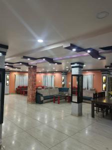 a lobby with couches and tables in a building at Domukha pali ghar in Chepti
