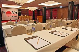 una sala de conferencias con mesas y sillas blancas en Nova Platinum Hotel, en Pattaya South