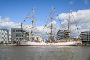 a large ship sitting in the water in a city at Schulschiff Deutschland Bremerhaven in Bremerhaven