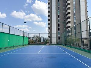 an empty tennis court in front of a building at Bann-Kun Impact Muang Thong 2BR Condo Wi-Fi MRT Pink Near Airport DM in Nonthaburi