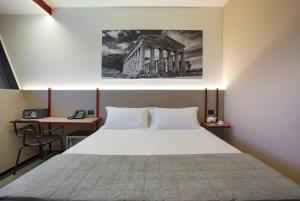 a bedroom with a bed and a desk and a building at CUBIK inn Design Rooms in Gravina di Catania