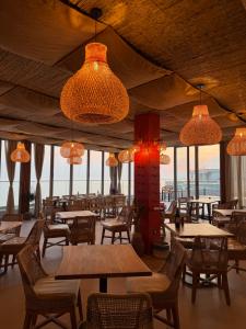 a restaurant with tables and chairs and lights at Sky rooftop luxury suites in Durrës
