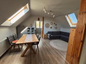 a living room with a table and a blue couch at Pioppo Apartman in Tiszavasvári