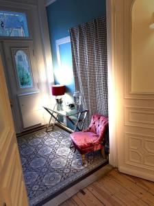 a room with a chair and a table and a door at Sleephotels Alsterroom in Hamburg