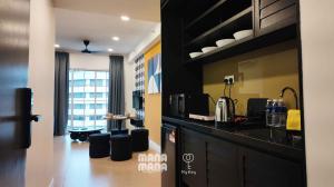 a kitchen with a counter and a living room at Stallionz by Mana Mana in Ipoh