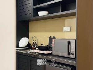 a kitchen with a microwave oven and a sink at Stallionz by Mana Mana in Ipoh