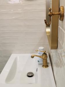 a white sink with a gold faucet in a bathroom at Casa Olive Costinești in Costinesti +31 photos