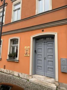 a orange building with a door and two windows at Ferienapartment Weimar Altstadt 2 in Weimar