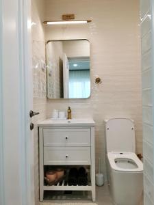 a bathroom with a toilet and a sink and a mirror at Casa Olive Costinești in Costinesti