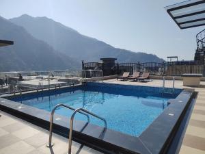 a swimming pool with a view of a mountain at Foxoso Heights, Tapovan in Rishīkesh
