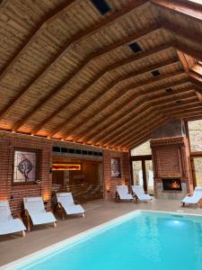 a large swimming pool with chairs and a fireplace at Hotel Sumski Feneri in Trnovo