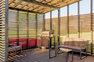 a screened in porch with two chairs and a grill at Pulli Country Club - Private Sauna & River View in Pärnu