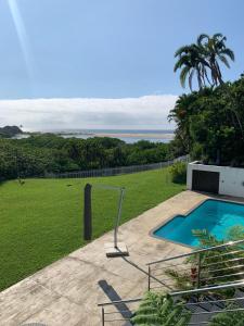 a house with a swimming pool and a green field at Villa Aurora in Margate