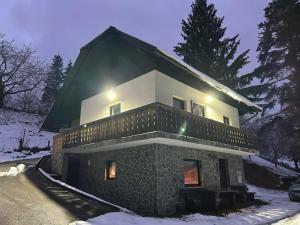 a house in the snow with lights on at Chalet Rozika Rogla in Zreče