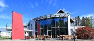 a building with tables and chairs in front of it at Hotel und Kongresszentrum Wanderath in Baar