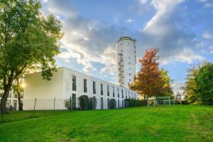 a white building with a grassy field in front of it at Jugendherberge Otto-Moericke-Turm in Konstanz