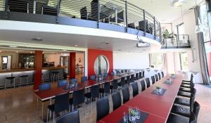 a dining room with a long table and chairs at Hotel und Kongresszentrum Wanderath in Baar +8 photos