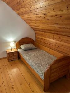 a bed in a room with a wooden wall at Chalet Rozika Rogla in Zreče