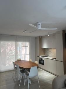 a kitchen with a wooden table and white chairs at Apartamento con WiFi y Aire acondicionado en Pals Playa in Pals