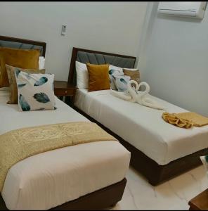 two beds sitting next to each other in a room at KJSGrandeInn in Manolo Fortich