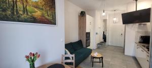 a living room with a green couch and a kitchen at Apartament 39 in Lublin