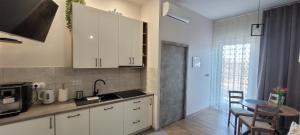 a kitchen with white cabinets and a table with a microwave at Apartament 39 in Lublin