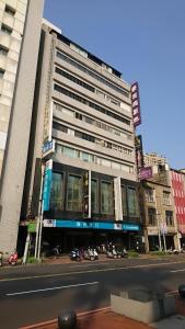 a large building with glass windows on a city street at H.M.Hotel in Hsinchu City