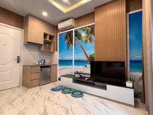 a kitchen with a large television and a view of the beach at Deco Harmony Pattaya 1 in North Pattaya