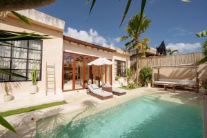 a villa with a swimming pool and a house at Villa Mahuwa in Canggu