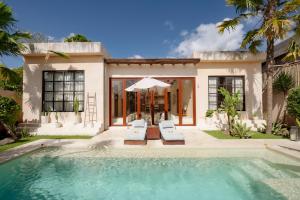 a villa with a swimming pool and a house at Villa Mahuwa in Canggu +38 photos