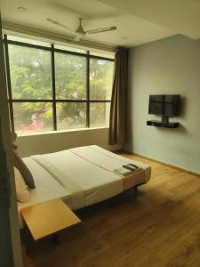 a bedroom with a large bed and a window at Hotel CINCO PRIME -PREMIUM ROOMS in Secunderabad +21 photos