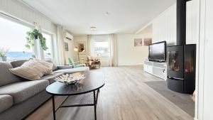 a living room with a couch and a tv and a table at Spacious apartment in Follebu in Aulestad