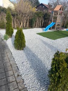 a rock garden with a playground and a slide at Appartementshaus Vlora 1 Einheit 2 in Bad Füssing +3 photos
