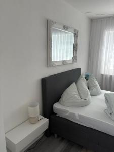 a bedroom with a bed and a mirror on the wall at Appartementshaus Vlora 1 Einheit 2 in Bad Füssing