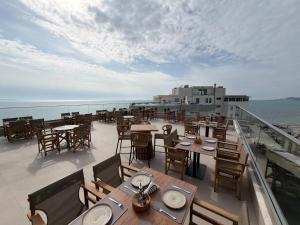 a restaurant with tables and chairs on the deck of a ship at Blumont aparthotel durres in Durrës