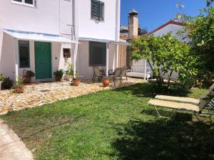 a patio with a bench in the yard of a house at Sidari High Street Apartment in Sidari +7 photos