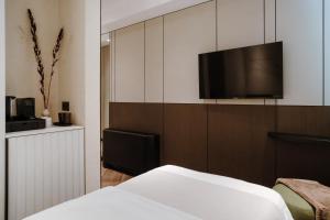 a bedroom with a bed and a flat screen tv at Ferdinand Boutique in Cluj-Napoca