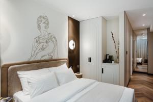 a bedroom with a bed with a drawing on the wall at Ferdinand Boutique in Cluj-Napoca