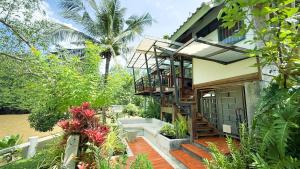 a house with a staircase leading to the front of it at Rimsira in Chumphon