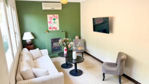 a living room with a white couch and a table at Hotel Les Rocailles in Montagnac