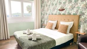 a bedroom with a bed with two teddy bears on it at Hotel Les Rocailles in Montagnac +84 photos