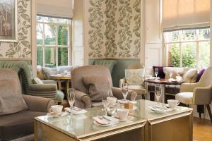 a dining room with chairs and tables and windows at Lainston House in Winchester