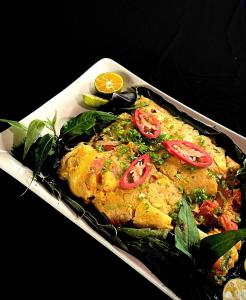 a plate of food with tomatoes on top of it at Mekong Silt Ecolodge - Swimming Pool & Free Breakfast in Can Tho