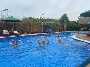 a group of people swimming in a swimming pool at Mekong Silt Ecolodge - Swimming Pool & Free Breakfast in Can Tho