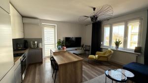 a living room with a kitchen and a living room with a couch at Apartament - U Alicji in Konin